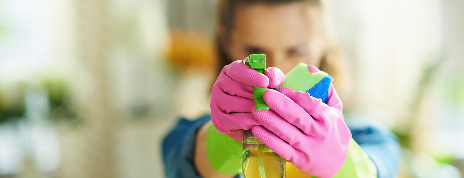 Frau mit Sprühflasche Reinigungsmittel