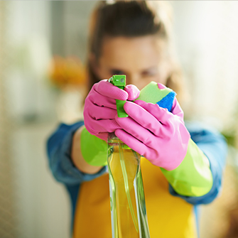 Frau mit Sprühflasche Reinigungsmittel