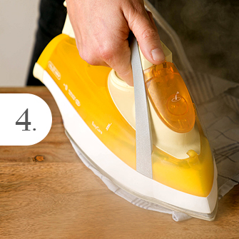 Schritt 4: Mit dem Bügeleisen über das feuchte Geschirrtuch bügeln, um Dellen im Holz auszubessern